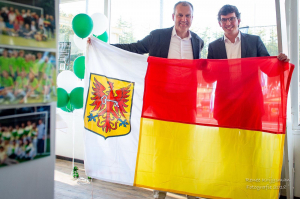 Wethouder Nathan Stukker overhandigt het kado van de gemeente, de vlag van Apeldoorn, aan voorzitter Edgar Breed